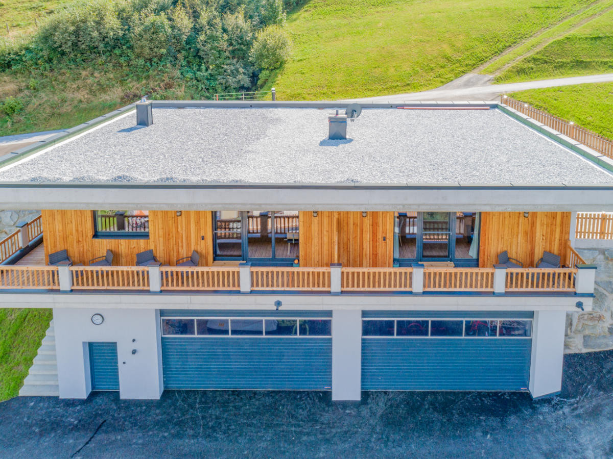 Das in die malerische Alpenlandschaft eingebettete Hoferlitzlhubgut in Mittersill bei sonnigem Wetter aus der Vogelperspektive.