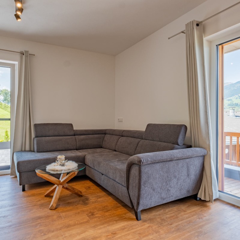 Gemütliche Sitzecke mit Glastisch in der Ferienwohnung Hoferlitzlhubgut in Mittersill, einladend und stilvoll gestaltet.