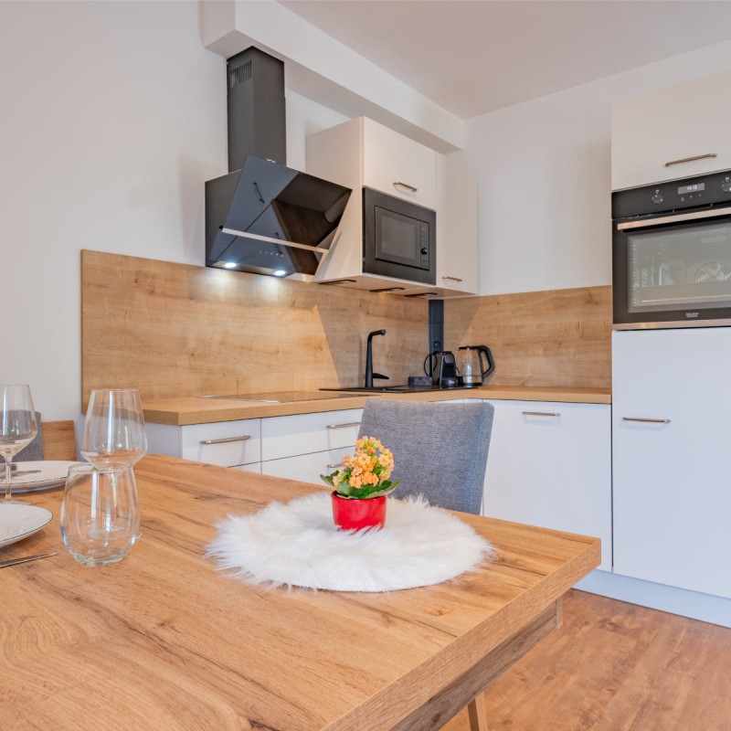 Ferienwohnung Hoferlitzlhubgut in Mittersill: Helle, moderne Küche mit gedecktem Tisch