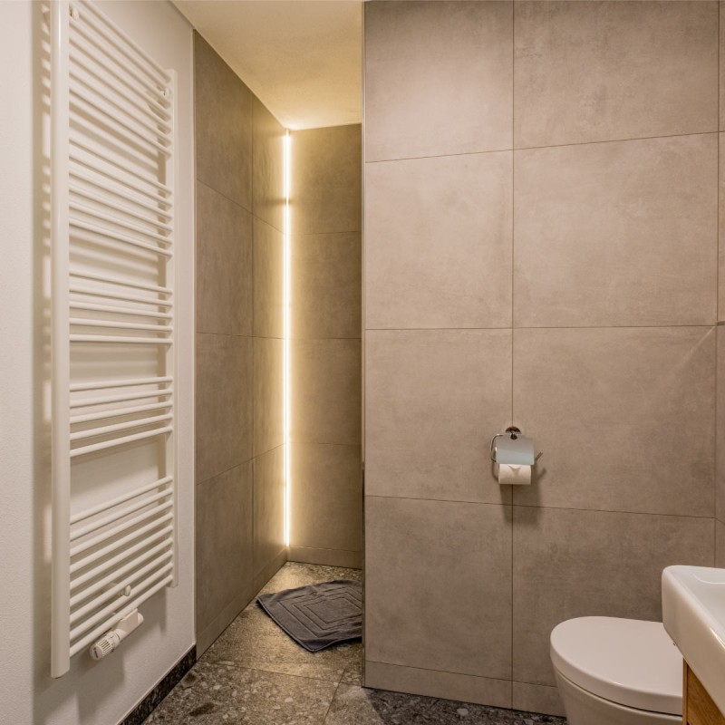 Hell beleuchtetes, modernes Badezimmer mit Handtuchtrockner in der Ferienwohnung Hoferlitzlhubgut in Mittersill.